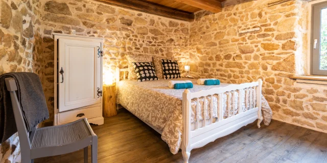 Chambre confortable et lumineuse dans le gîte de la Neira à Ravel, avec décoration rustique.