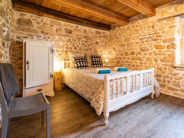 Chambre confortable et lumineuse dans le gîte de la Neira à Ravel, avec décoration rustique.