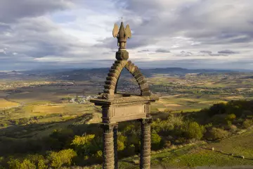 Vercingetorix Monument, 1903, by Jean Teillard, made from volcanic stone from Volvic, aerial view, on the Plateau de Gergovie, or Gergovia Plateau, ite of the Battle of Gergovia between Vercingetorix, Gaulish Arverni chieftain, and Julius Caesar in 52 BC, which the Gauls won, in the Massif Central, Auvergne, France. Gallic settlement in Gergovia was at its height in the 3rd and 2nd centuries BC. Picture by Manuel Cohen