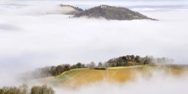 Un paysage montagneux avec de la brume couvrant les vallées, laissant apparaître des sommets, photographié par Daniel Bost.