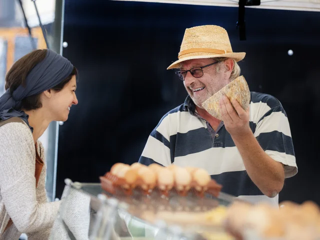 Un producteur au marché de Billom échange avec une cliente.