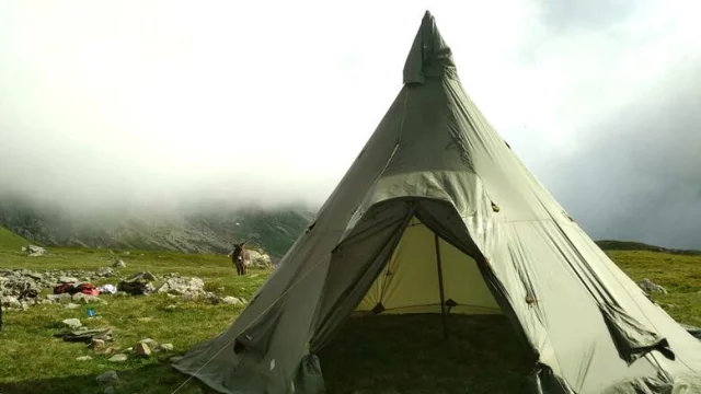 Un tipi en pleine nature, entouré de paysages hivernaux avec un âne visible au loin, pour une activité d'observation naturaliste et de découverte des espèces locales