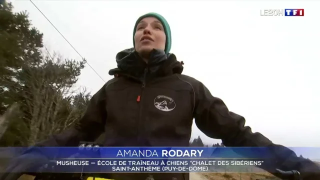 Amanda Rodary, musheuse, sur son traîneau à chiens, vêtue d’une veste et d’un bonnet, dans les montagnes de Saint-Anthème.