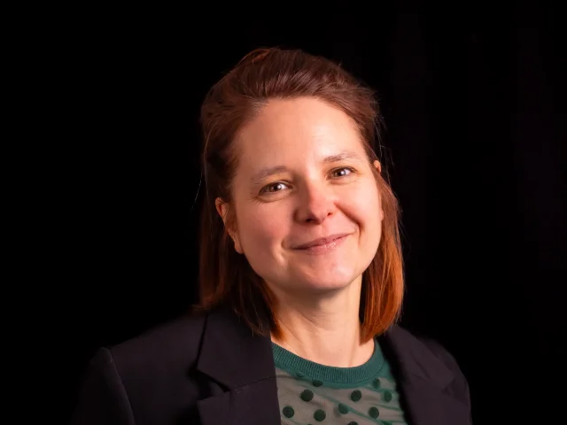 Portrait de Céline Roche, membre de l’équipe, en tenue formelle, souriante