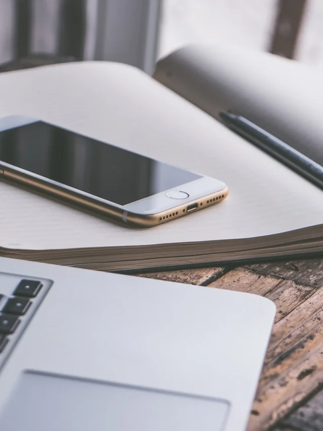 Smartphone sur un cahier avec clavier d’ordinateur en premier plan.